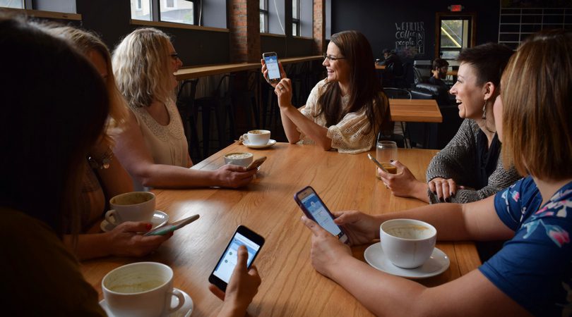 a group of women at a coffee shop talking about the Komae app
