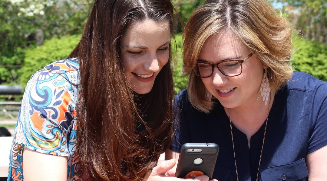 Amy Husted and Audrey Wallace the Co-Founders of Komae looking at a phone