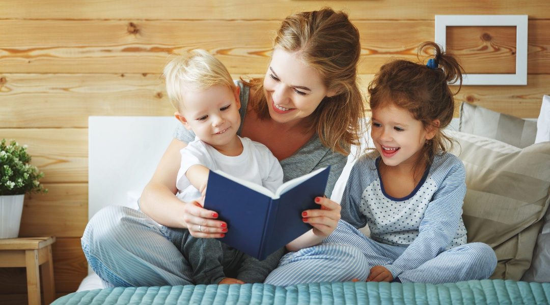 a mom reading a book to her two children