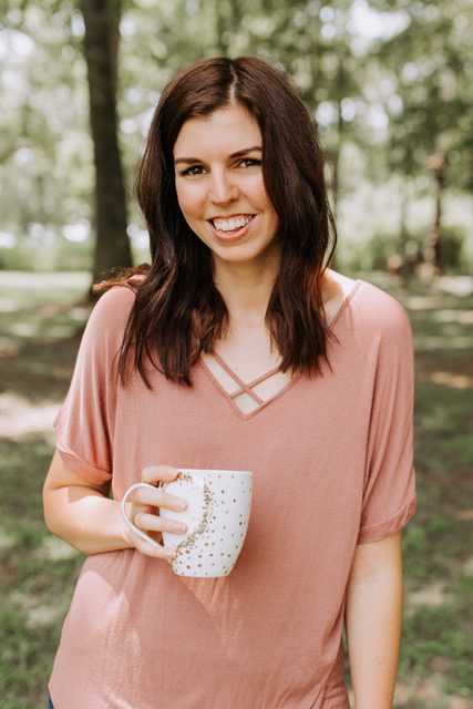a woman in a pink blouse holding a polka dot mug
