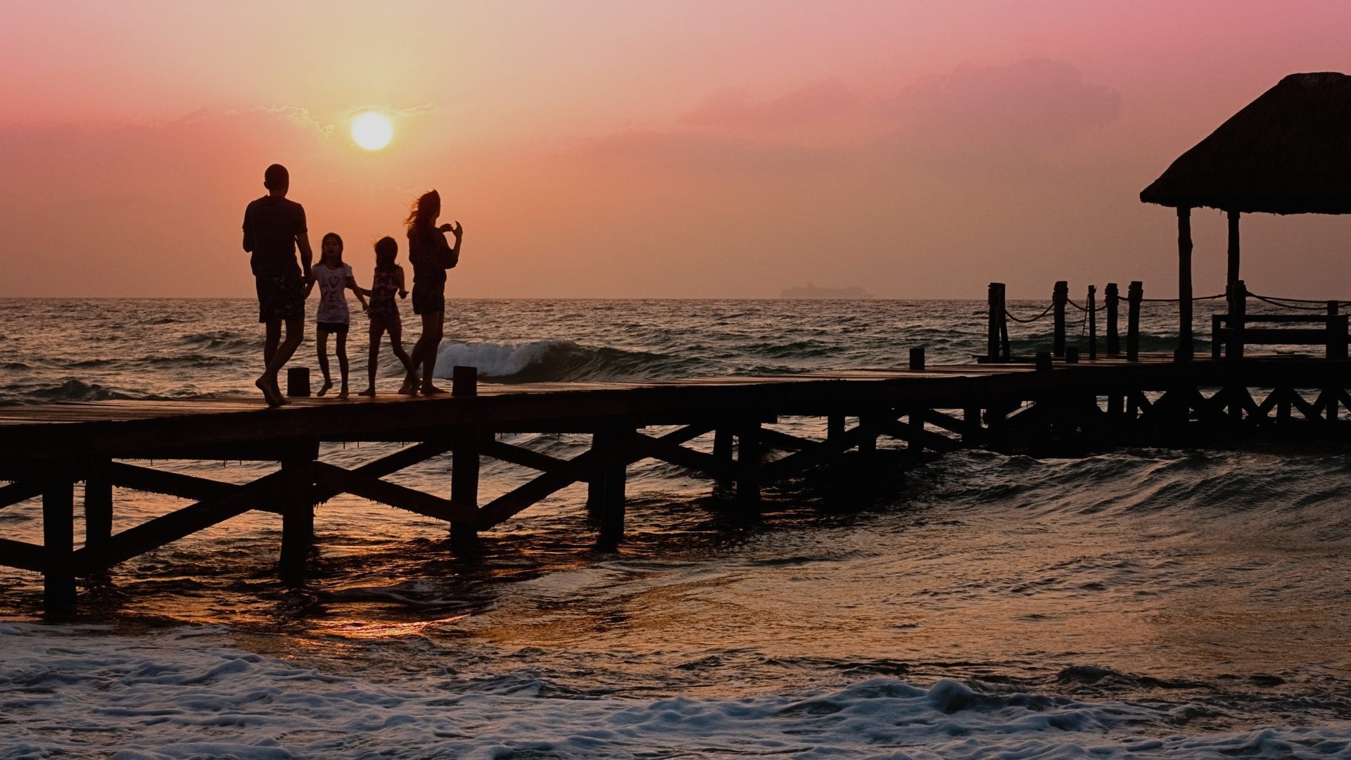 a family walking on a dock to the ocean